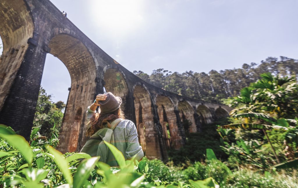 Woman looks at the Demodara nine arches bridge the most visited sight of Ella town in Sri Lanka, Travel to Asia