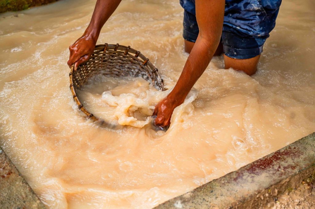Man washes rattan pan with mined gemstones, Sri Lanka Voyages 